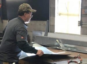 Cutting and bending sheet metal to create ductwork.